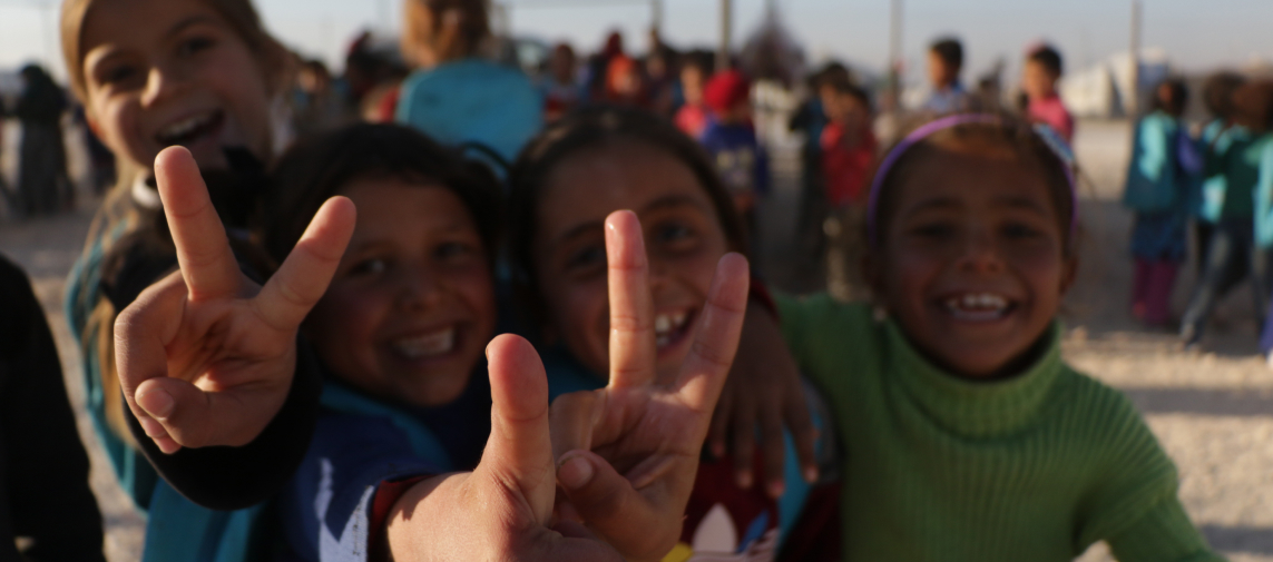 Syrian girls smiling in refugee camp